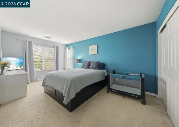 a spacious bedroom with a bed and a window