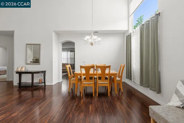 a dining room with furniture a chandelier and wooden floor