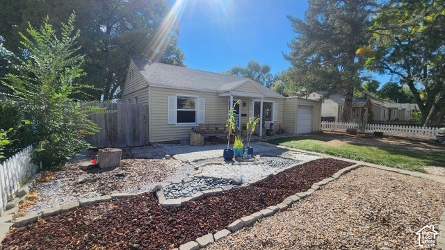 964 300 North Provo, UT 84606 - Photo 2 of 4 Single-story residence featuring light-colored siding, a white picket fence, and a single-car garage