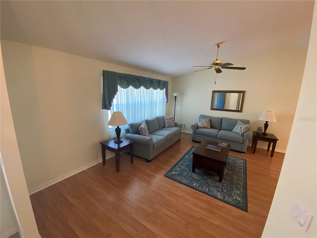 26840 Racquet Circle Leesburg, FL 34748 - Photo 3 of 19 a living room with furniture and a wooden floor