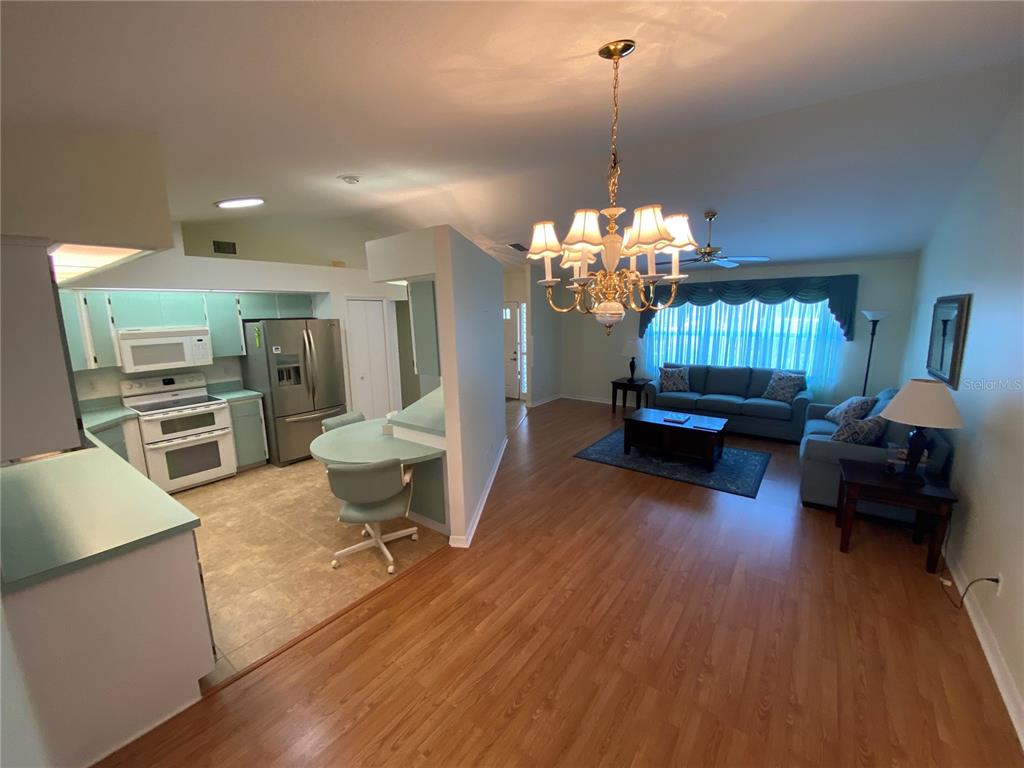 26840 Racquet Circle Leesburg, FL 34748 - Photo 5 of 19 a living room with furniture and a chandelier