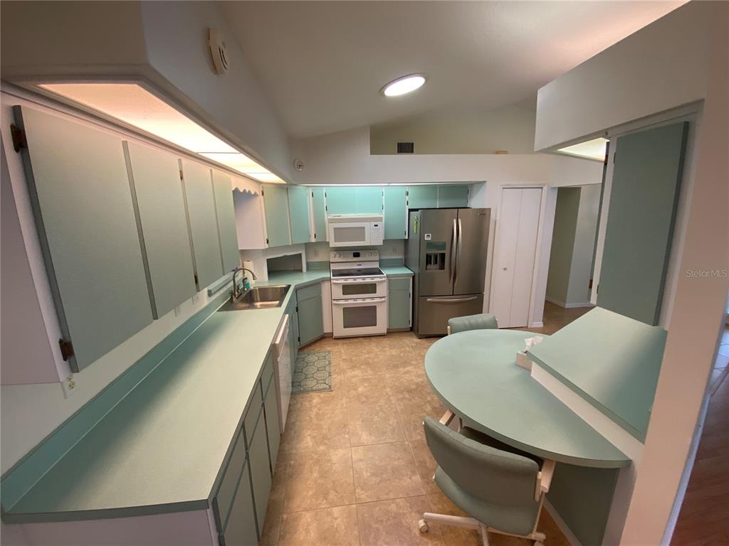 26840 Racquet Circle Leesburg, FL 34748 - Photo 6 of 19 a large kitchen with a table and chairs