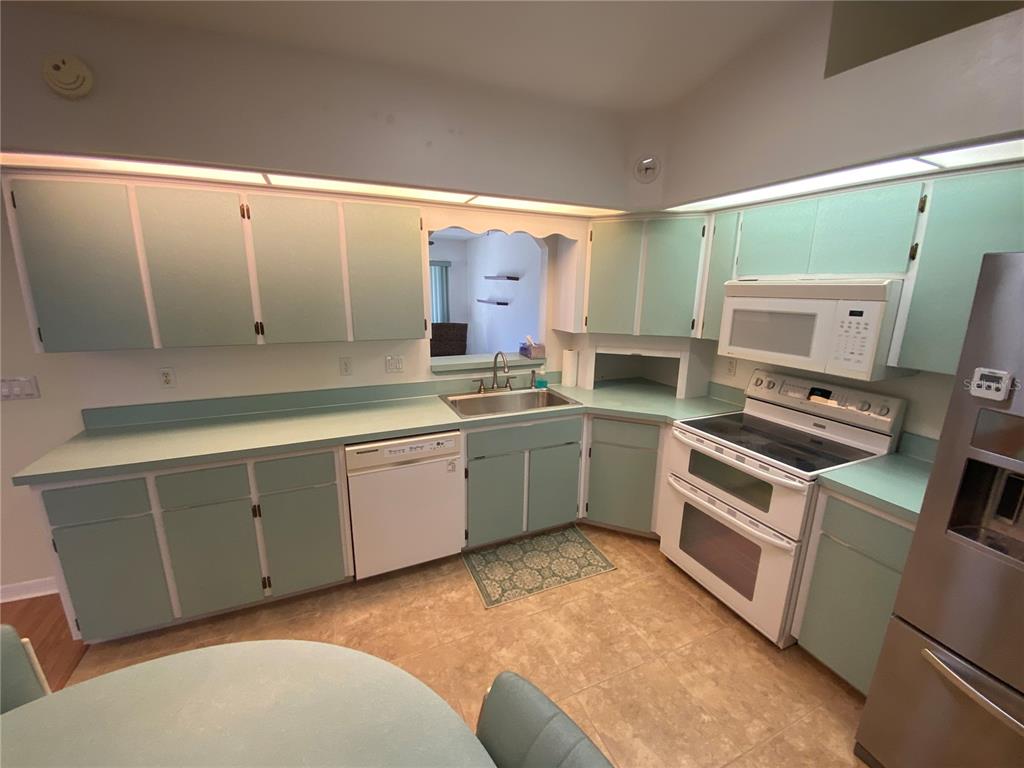 26840 Racquet Circle Leesburg, FL 34748 - Photo 7 of 19 a kitchen with a stove a sink and a refrigerator
