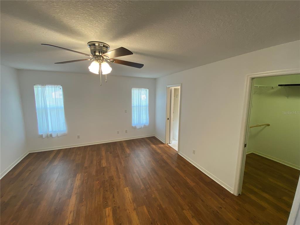 26840 Racquet Circle Leesburg, FL 34748 - Photo 10 of 19 a view of an empty room with a window and wooden floor