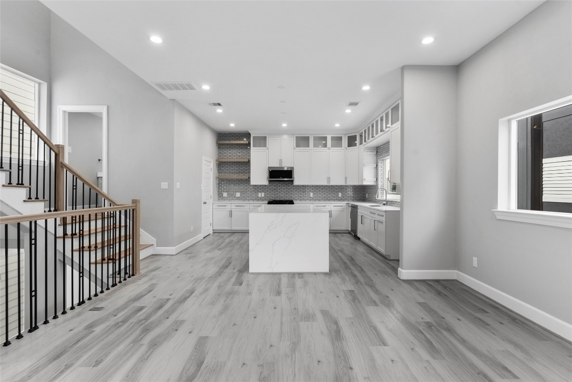 1122 West 16th Street, Unit B Houston, TX 77008 - Photo 12 of 31 View of kitchen from the dining area with access to the powder room on the landing of the stairs