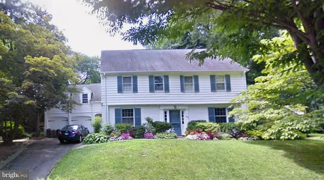 a front view of a house with a yard and potted plants