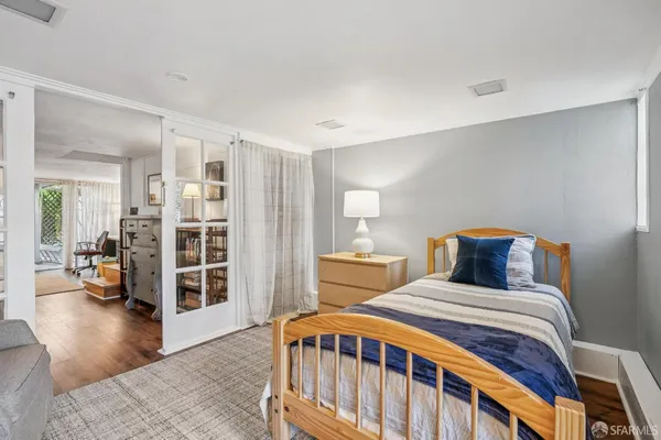 a bedroom with a bed and wooden floor