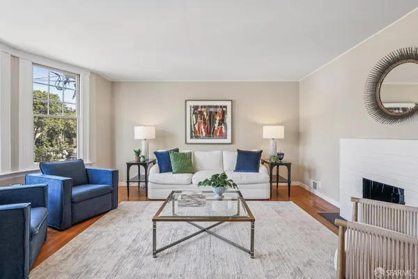 a living room with furniture a rug a window and a fireplace