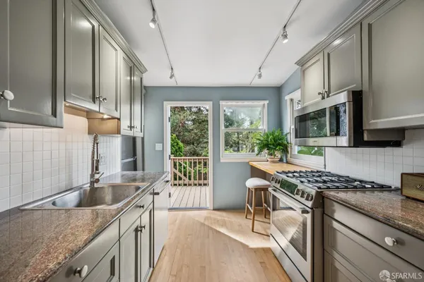 a kitchen with stainless steel appliances granite countertop a sink stove and cabinets