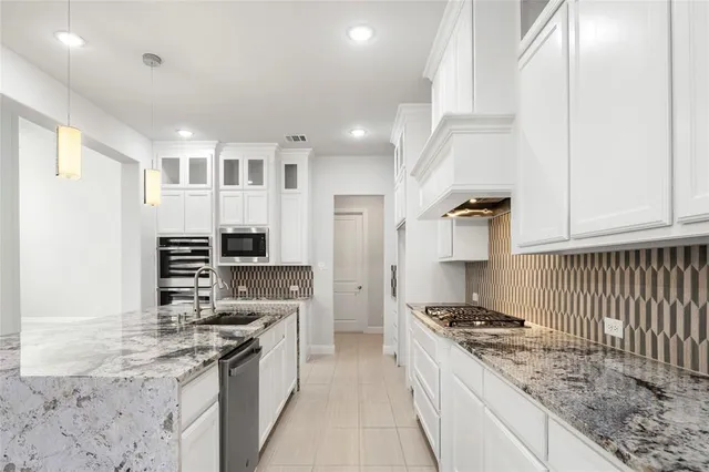 a kitchen with stainless steel appliances granite countertop a stove and a sink