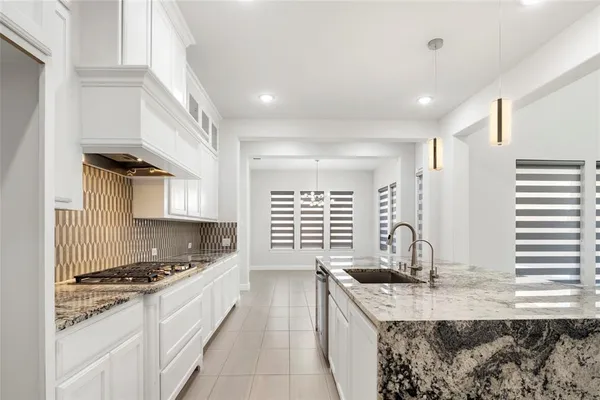 a kitchen with granite countertop a sink and a stove