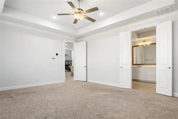 an empty room with closet and a ceiling fan