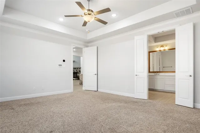 an empty room with closet and a ceiling fan