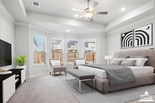 a bedroom with a bed a couch and a flat tv screen on dresser