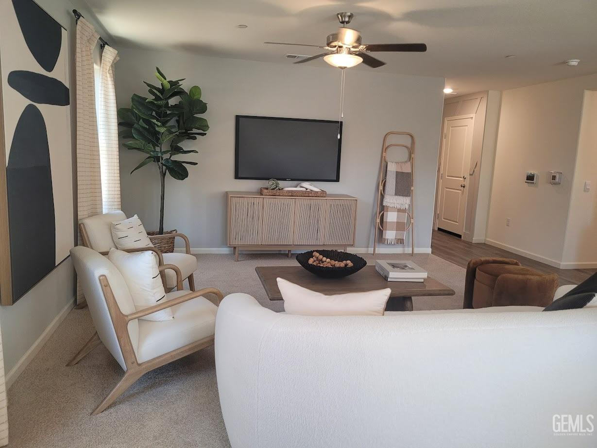 Undisclosed Address Bakersfield, CA 93307 - Photo 22 of 23 a living room with furniture a flat screen tv and a refrigerator
