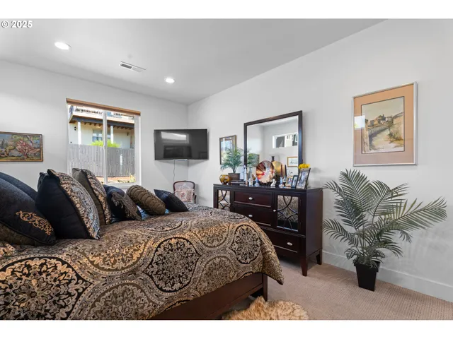 a bedroom with furniture and a flat screen tv