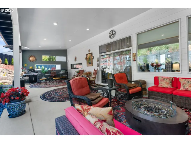 a living room with furniture a rug and a floor to ceiling window