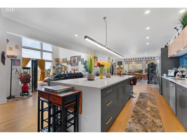 a kitchen with stainless steel appliances kitchen island granite countertop a table chairs sink and cabinets