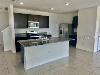31284 Penny Surf Loop Wesley Chapel, FL 33545 - Photo 4 of 15 a kitchen with stainless steel appliances granite countertop a refrigerator and a stove top oven