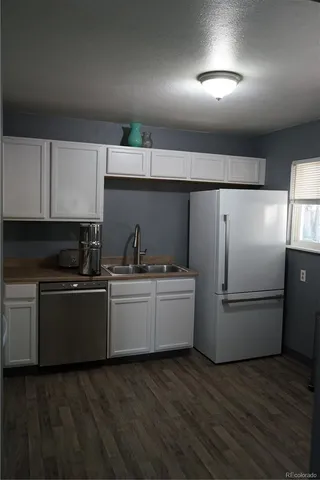 a kitchen with a refrigerator and a sink