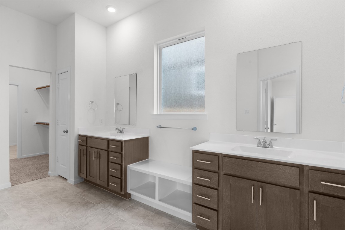 13821 Tucker Hedge Pass Elgin, TX 78621 - Photo 12 of 31 Bathroom with two vanities, a spacious closet, and recessed lighting