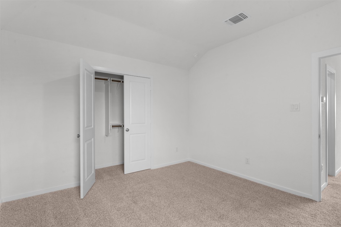 13821 Tucker Hedge Pass Elgin, TX 78621 - Photo 20 of 31 Unfurnished bedroom with light carpet, vaulted ceiling, and a closet