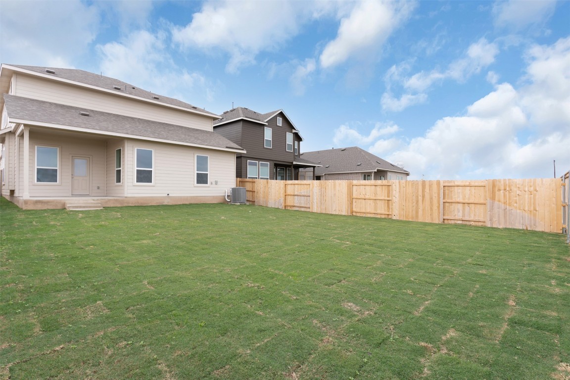 13821 Tucker Hedge Pass Elgin, TX 78621 - Photo 22 of 31 Back of property with a fenced backyard and a patio area