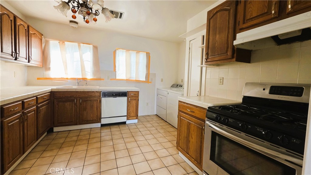 488 Royce Street Altadena, CA 91001 - Photo 5 of 10 a kitchen with stainless steel appliances granite countertop a stove a sink and a microwave
