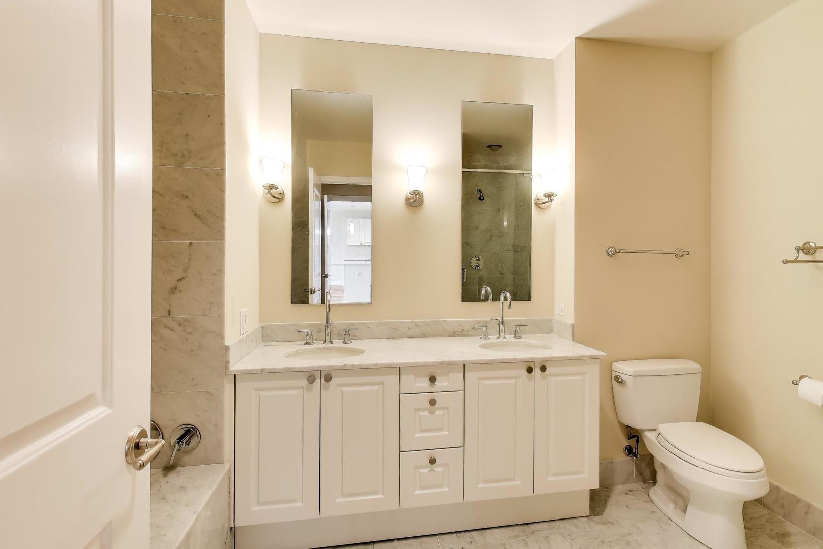 10 East Delaware Place, Unit 20A Chicago, IL 60611 - Photo 15 of 42 a bathroom with a granite countertop toilet sink and mirror