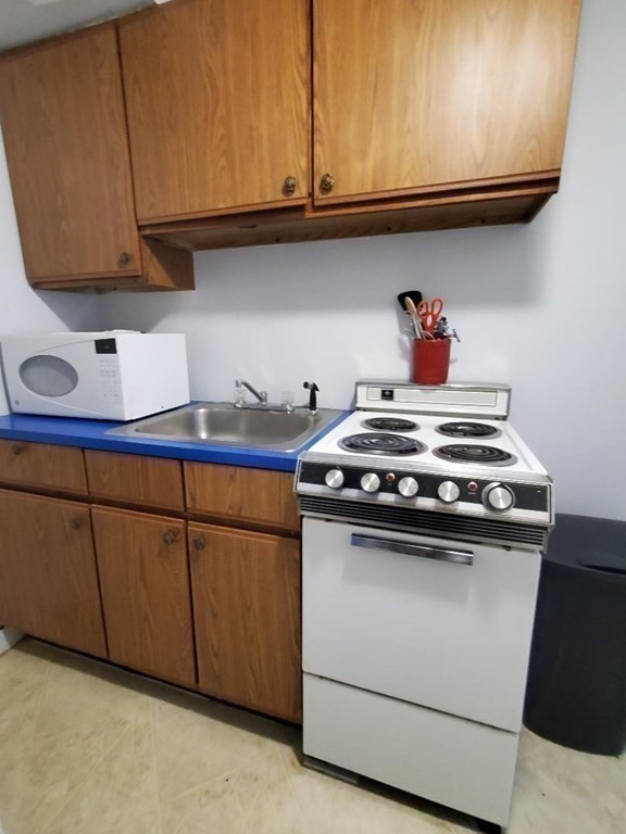 a kitchen with granite countertop cabinets and a stove top oven