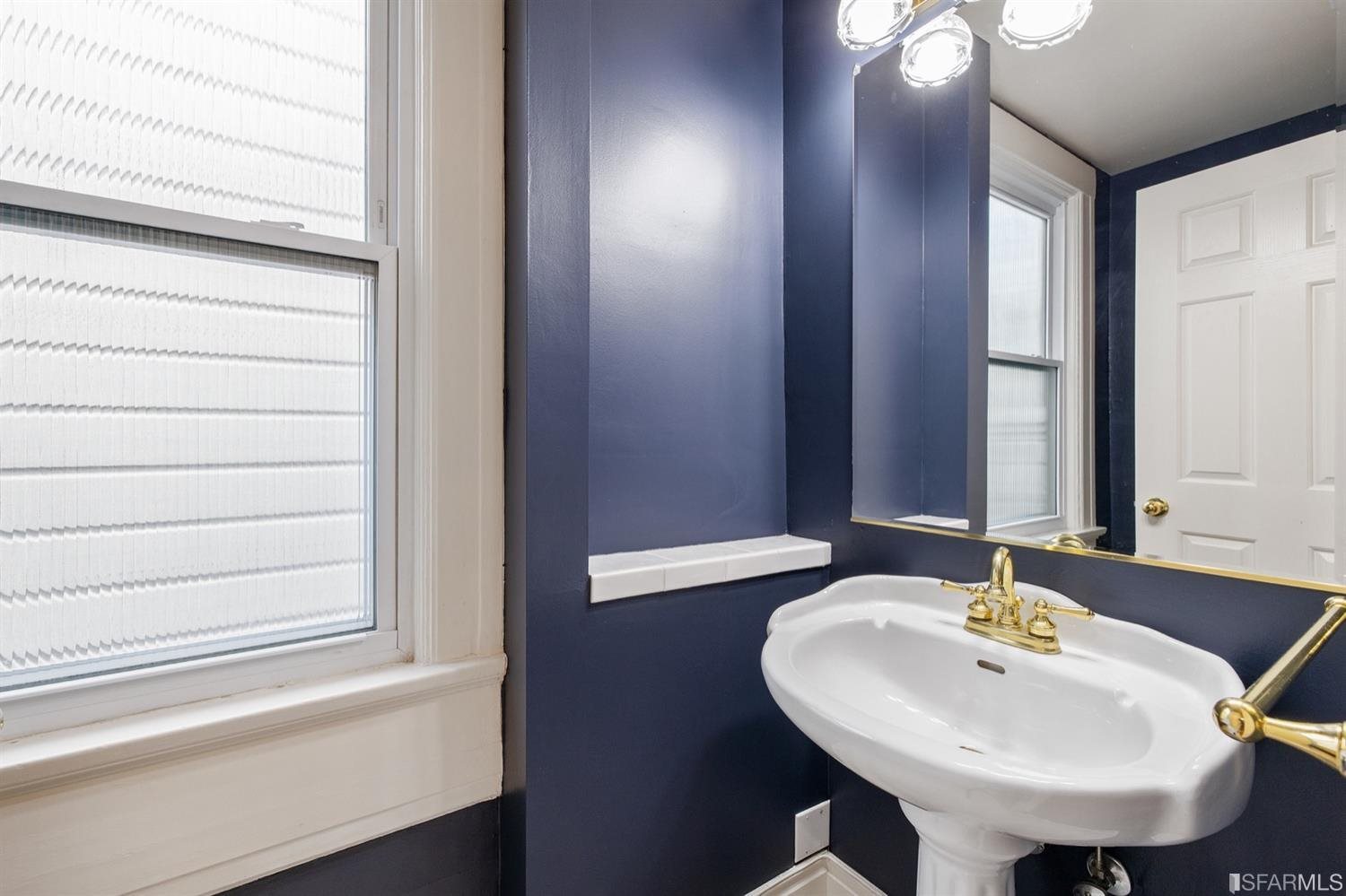 1069 Broadway San Francisco, CA 94133 - Photo 11 of 43 a bathroom with a sink and a mirror