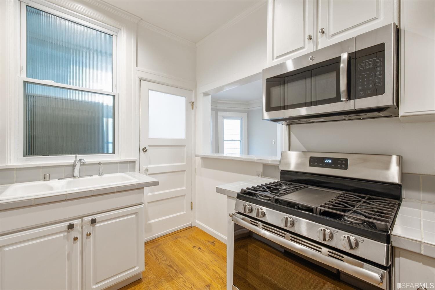 1069 Broadway San Francisco, CA 94133 - Photo 2 of 43 a kitchen with stainless steel appliances a stove a microwave and sink