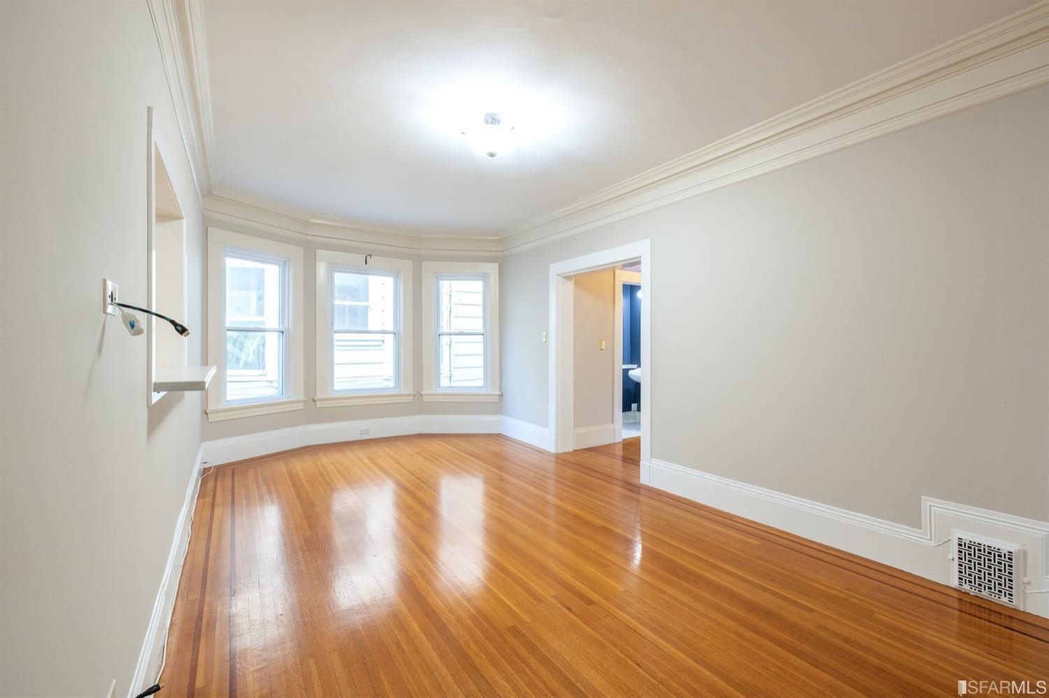 1069 Broadway San Francisco, CA 94133 - Photo 27 of 43 an empty room with wooden floor and windows