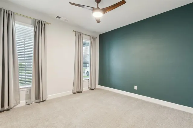 an empty room with windows and closet area