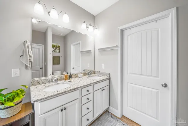 a bathroom with a granite countertop sink a mirror and a shower