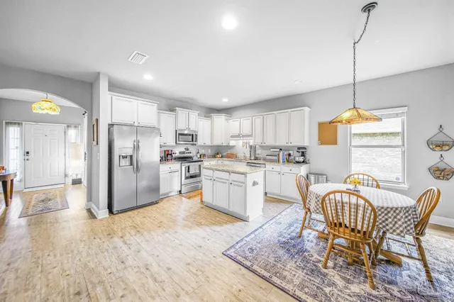 a kitchen with refrigerator a sink and chairs