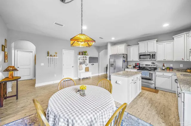 a kitchen with microwave a stove and wooden floor