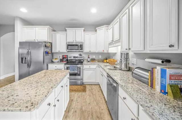 a kitchen with stainless steel appliances granite countertop a refrigerator sink and cabinets