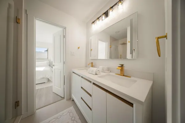a bathroom with a sink a toilet and a mirror