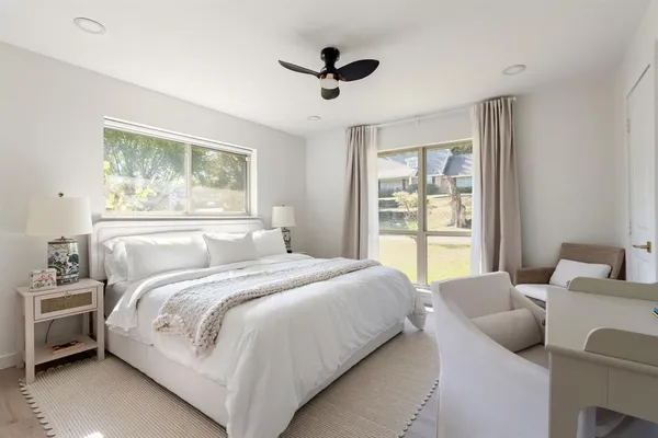 a bedroom with bed and a large window