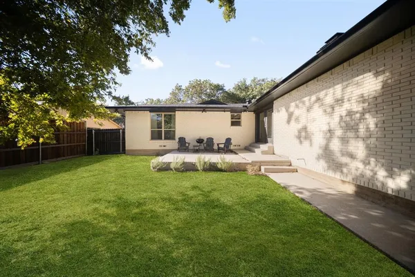 a view of house with backyard and a garden