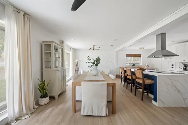 a dining room with furniture potted plants and wooden floor