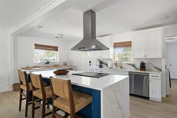 a kitchen with a stove a sink a table and chairs