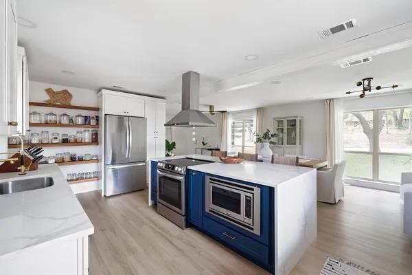 a kitchen with stainless steel appliances a stove top oven and a refrigerator