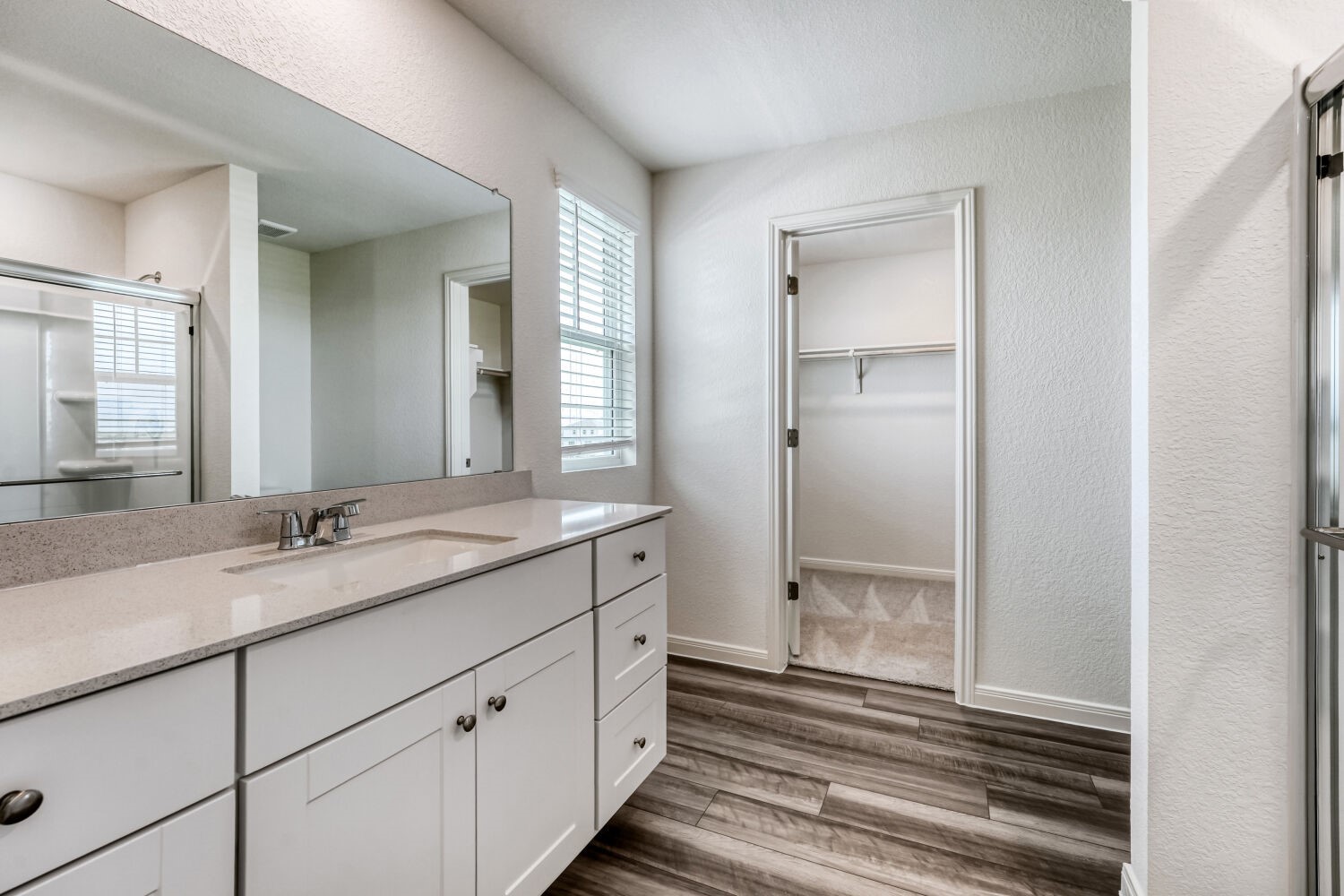 124 Mullen Way Taylor, TX 76574 - Photo 19 of 22 Bathroom featuring an extended vanity with dual sinks, light-toned countertop, and white cabinetry