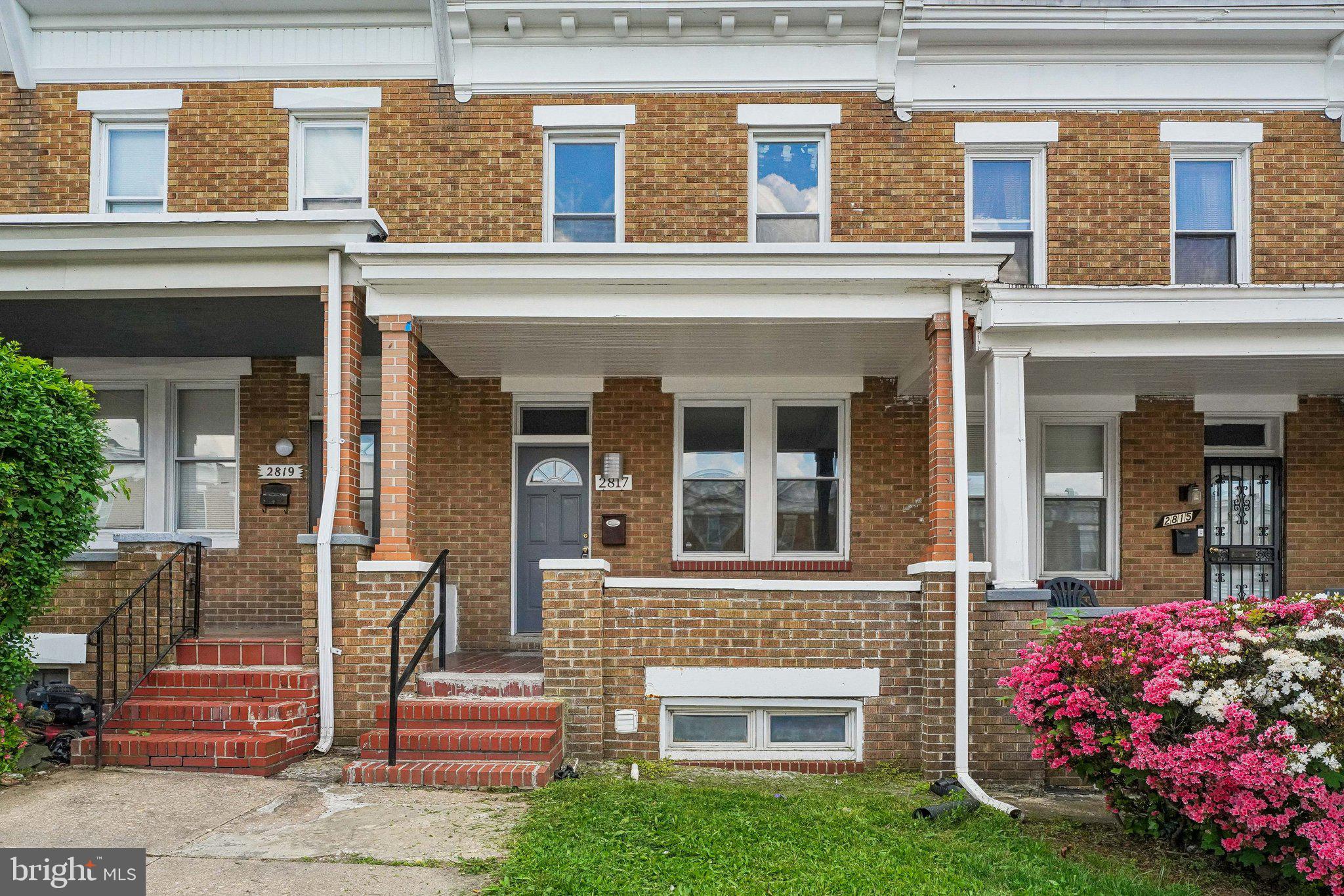 front view of a brick house with a yard