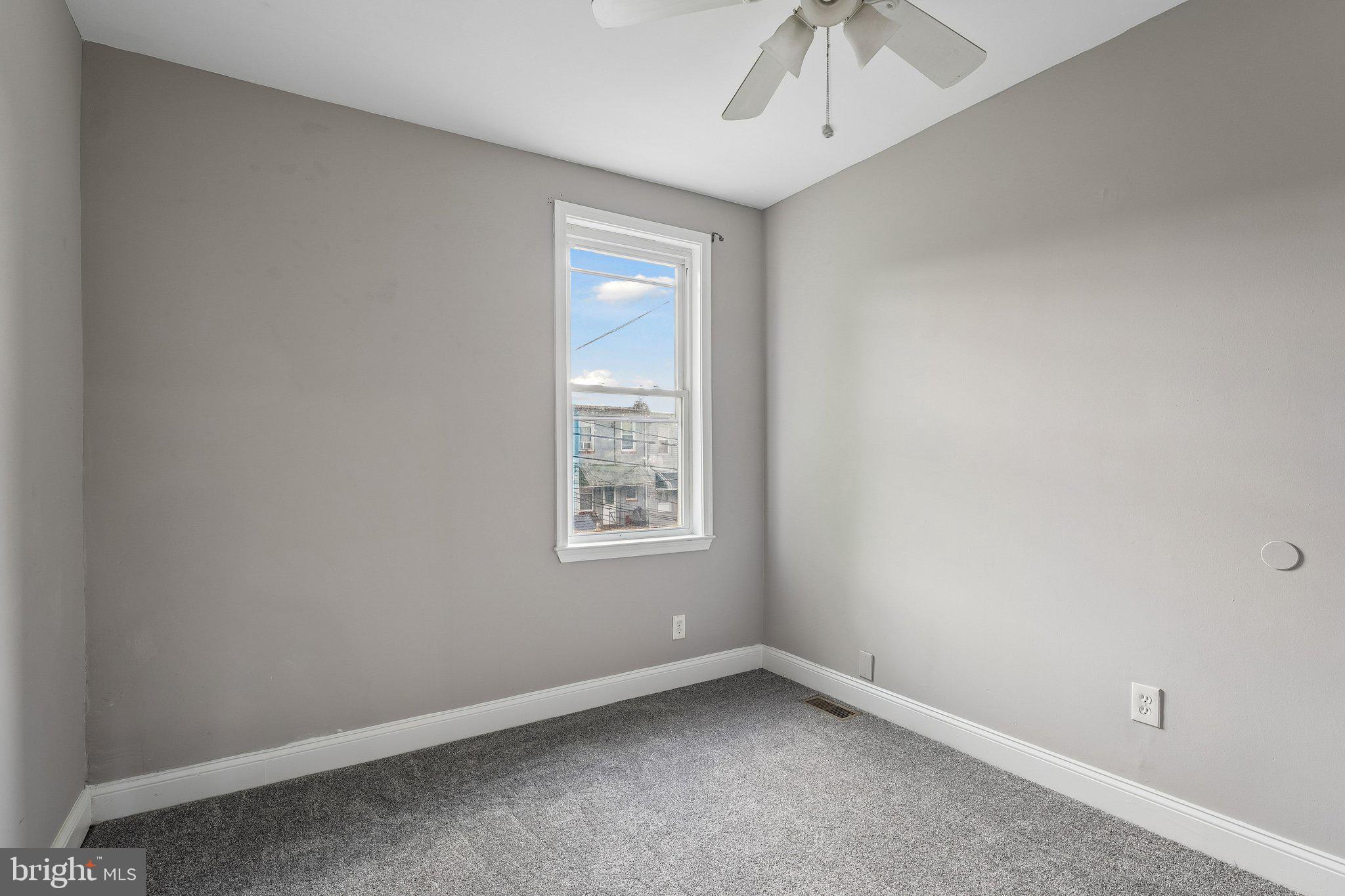 2817 Pelham Avenue Baltimore, MD 21213 - Photo 13 of 25 an empty room with a window and a fan