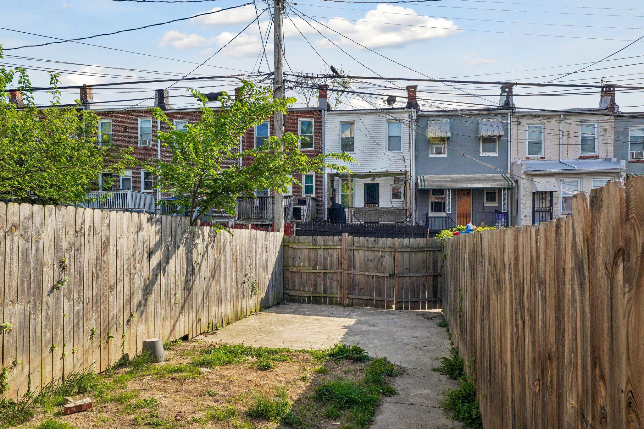 2817 Pelham Avenue Baltimore, MD 21213 - Photo 24 of 25 a view of a brick house with a small yard and wooden fence