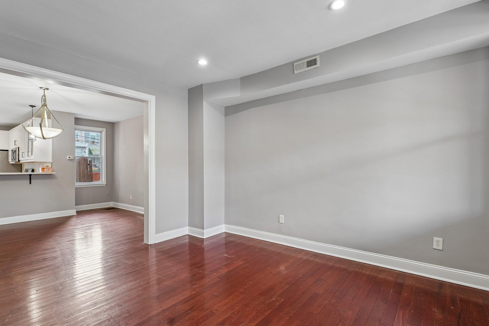 2817 Pelham Avenue Baltimore, MD 21213 - Photo 5 of 25 an empty room with wooden floor and a empty space