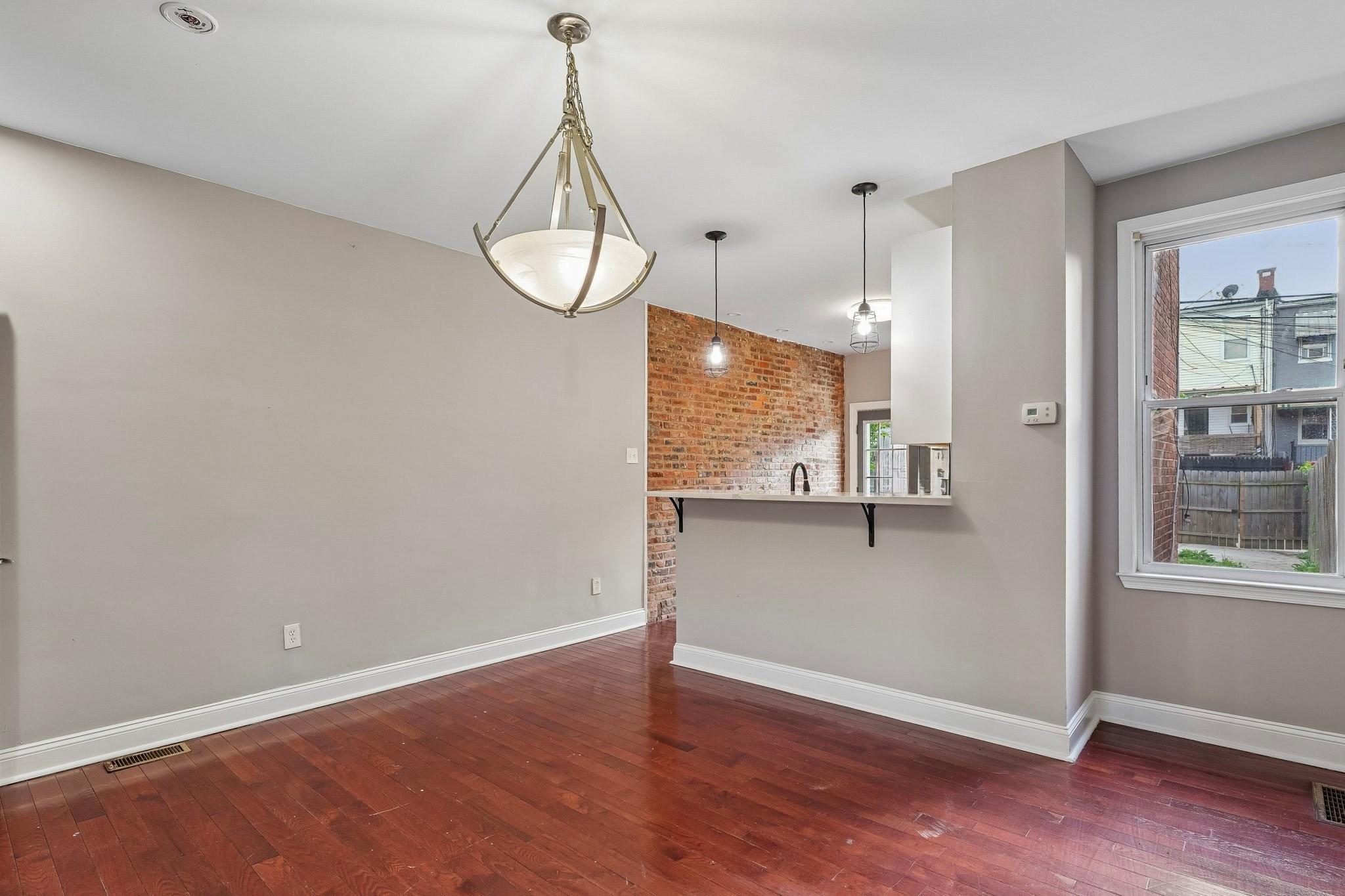 2817 Pelham Avenue Baltimore, MD 21213 - Photo 8 of 25 a view of a room with wooden floor and windows
